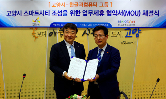 김상철 한컴그룹 회장(오른쪽)과 최성 고양시장이 스마트시티 조성 업무협약을 체결한 후 기념촬영을 하고 있다.   한컴 제공